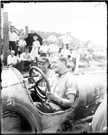 Automobile mechanic Tom Alley sitting in the driver's seat of an automobile parked on the side of a road during Elgin Auto Races - Chicago Daily News, Inc.
