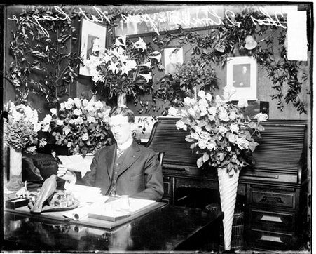 Charles H Thomas, president Cubs, holding a piece of paper, sitting at a desk in a room - Chicago Daily News, Inc.