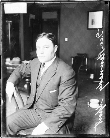Sports, George Kennedy sitting in chair in office - Chicago Daily News, Inc.