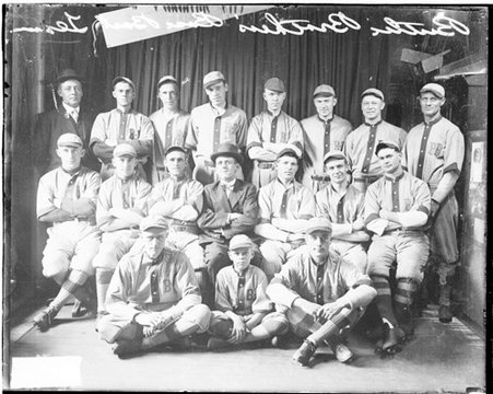 Baseball, Butler Bros. players, coaches, and mascot posing in front of dark backdrop - Chicago Daily News, Inc.