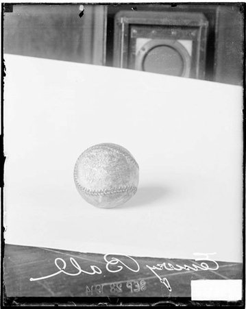 Emery baseball sitting on a light-colored surface on a table in a room - Chicago Daily News, Inc.