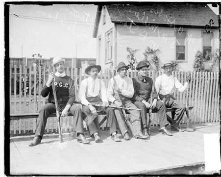 Marksmen, William Stannard, Frank Stanton, W. A. Davis, J. N. Miller, and J. R. Graham, holding rifles, sitting on a bench on a deck - Chicago Daily News, Inc.