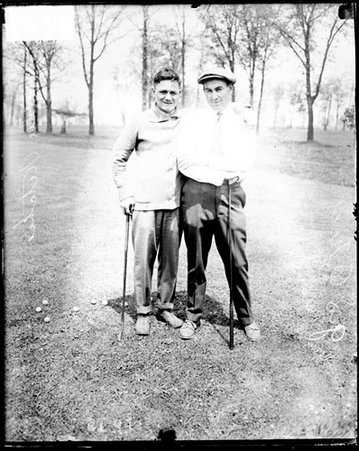 Pugilist Willie Ritchie and an unidentified man holding golf clubs on the grounds of an unidentified golf club - Chicago Daily News, Inc.