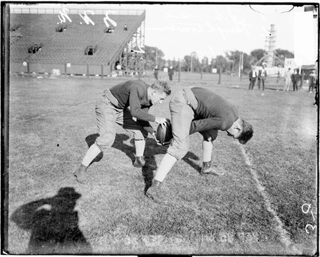 Northwestern University football player hiking a football to a team member on an athletic field, one of the football players is William Hightower - Chicago Daily News, Inc.