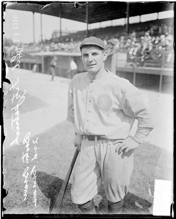 Baseball player, Boston, Ed Fitzpatrick leaning on bat standing on field at Weeghman Park - Chicago Daily News, Inc.