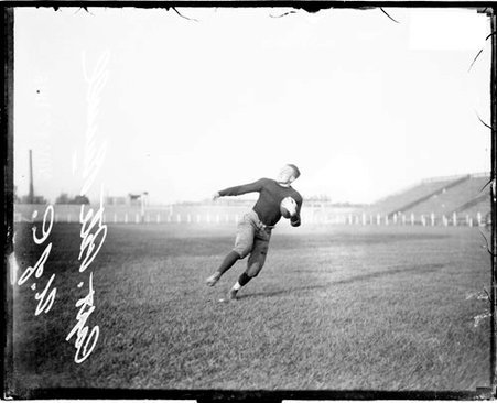 Football player, Russell, University of Chicago, cradling football in left arm, running at Stagg Field - Chicago Daily News, Inc.