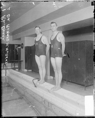 Swimmers, R. L. Doran and Richard N. Hubeny standing on edge of swimming pool at indoor gym - Chicago Daily News, Inc.