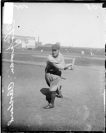 Chapman, a baseball player for Cleveland, holding bat after swinging and standing on field at Comiskey Park - Chicago Daily News, Inc.