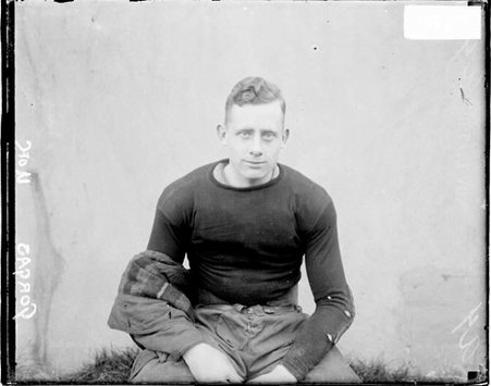 Football player, Gorga sitting in front of light backdrop outside on athletic field - Chicago Daily News, Inc.