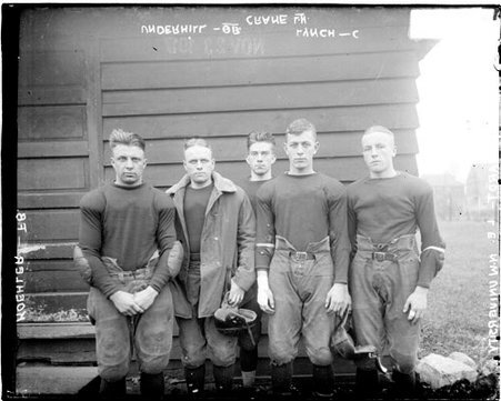 Football players, Robert Koehler, Crane, Lynch, Marquardt, and M. P. Underhill standing in front of building, Northwestern - Chicago Daily News, Inc.