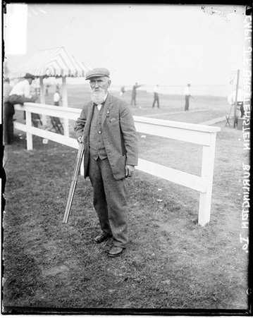 Shooter, J. F. Breitenstein standing in front of light fence and shooting range - Chicago Daily News, Inc.