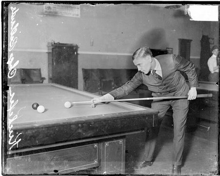 Billiards player, Augie Kiechefer facing right of image ready to shoot with cue stick, standing next to table - Chicago Daily News, Inc.