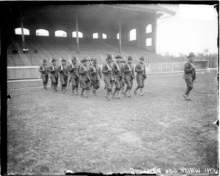 Baseball team, White Sox, drilling in army uniforms holding bats over shoulders while marching in front of grandstands - Chicago Daily News, Inc.