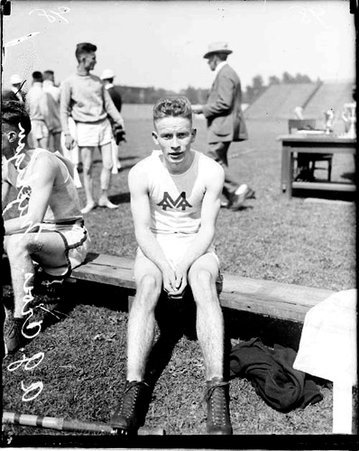 Track athlete, A.G. Cross, sitting on a bench at Stagg Field - Chicago Daily News, Inc.