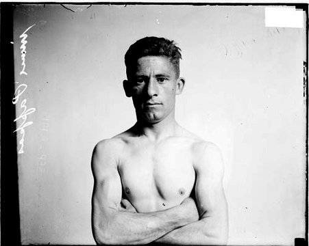 Pugilist, Jimmy Pappas standing in front of a light-colored backdrop in a room - Chicago Daily News, Inc.