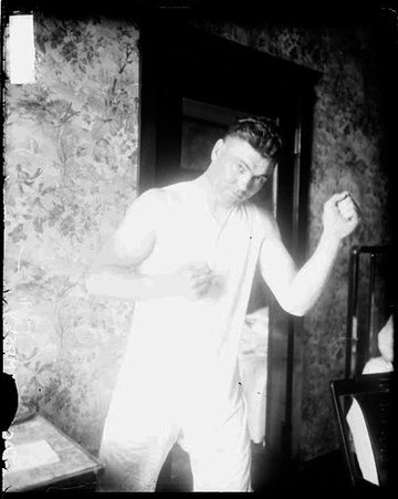 Boxer, Jack Dempsey standing in a boxing stance in a room - Chicago Daily News, Inc.