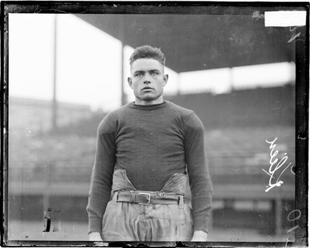 Football player Klein standing outdoors in front of grandstands - Chicago Daily News, Inc.
