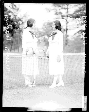 Tennis players, Dorothy Curtis and Loretta Hines holding rackets, standing on tennis court - Chicago Daily News, Inc.