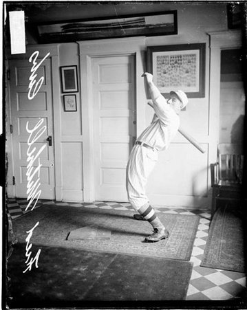 Baseball player Fred Mitchell, Cubs, leaning backwards, standing in front of a light-colored wall in a room - Chicago Daily News, Inc.