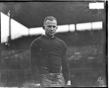 Football player Schroeder standing outdoors in front of grandstands - Chicago Daily News, Inc.