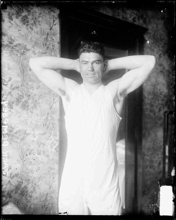 Boxer, Jack Dempsey standing with his hands behind his head in a room - Chicago Daily News, Inc.