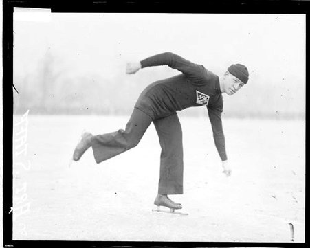 Ice skater Art Staff wearing ice skates and leaning forward, skating on a frozen body of water - Chicago Daily News, Inc.