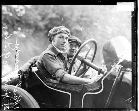 Motorist Paul Harvey in the driver's seat of a Peugeot automobile parked outdoors - Chicago Daily News, Inc.