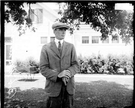 Golfer, Bob McDonald, holding a golf club, standing in front of a building - Chicago Daily News, Inc.