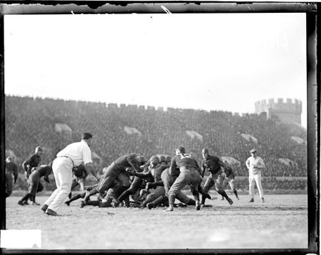 University of Chicago and Wisconsin football game, players grappling in a tackle on the field at Stagg Field - Chicago Daily News, Inc.