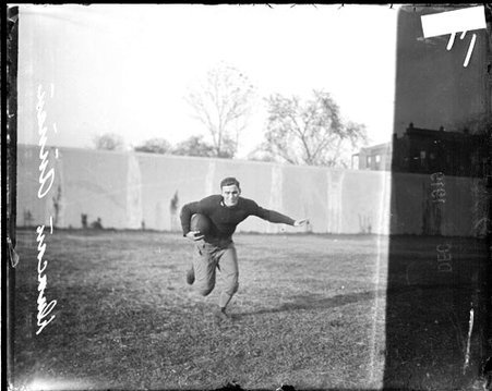 University of Chicago football player Duncan holding a football and running towards the camera - Chicago Daily News, Inc.