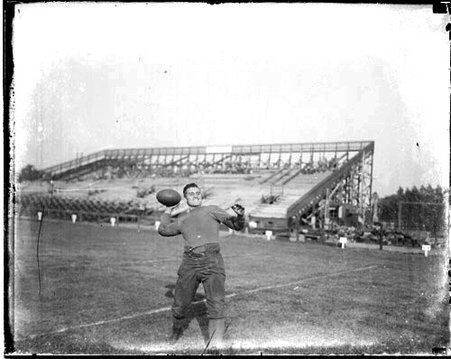 Northwestern University football player Langenstein cocking his arm to throw a football, standing on an athletic field in or near Evanston, Illinois - Chicago Daily News, Inc.