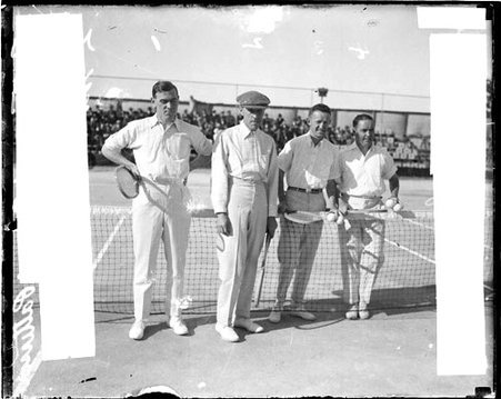 Tennis players, Patterson, Griffin, Brookes, and Johnston facing the camera, standing at the net on tennis court - Chicago Daily News, Inc.
