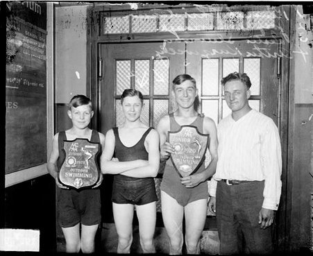 Swimmers Christensen, Kavanagh, Steinway Kurzwelly standing in a room - Chicago Daily News, Inc.