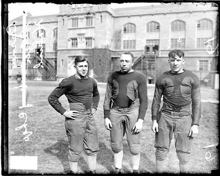 University of Chicago football players Barney, Setzer, and Hanisch standing on the field at Stagg Field - Chicago Daily News, Inc.
