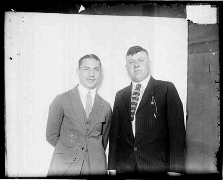 Pugilist, Benny Leonard standing with an unidentified in front of light-colored backdrop in a room - Chicago Daily News, Inc.