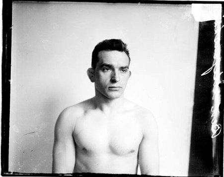 Wrestler Ben Stefanski sitting in front of a backdrop in a room - Chicago Daily News, Inc.