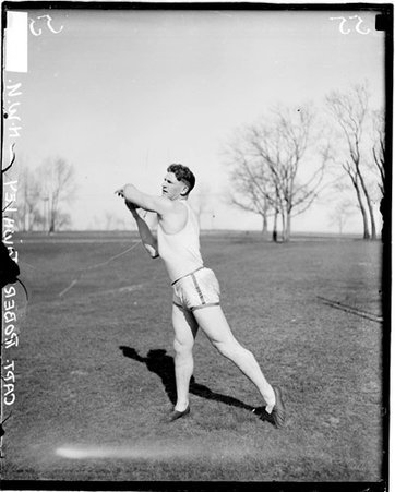 Northwestern University track and field athlete Townley following through after throwing a discus - Chicago Daily News, Inc.