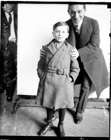 Boy chess player Sammy Rzeszewski standing in front of a light-colored backdrop in a room - Chicago Daily News, Inc.