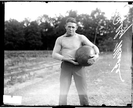 Pugilist, Billy Miske wearing street clothes and holding a large ball, standing outdoors - Chicago Daily News, Inc.