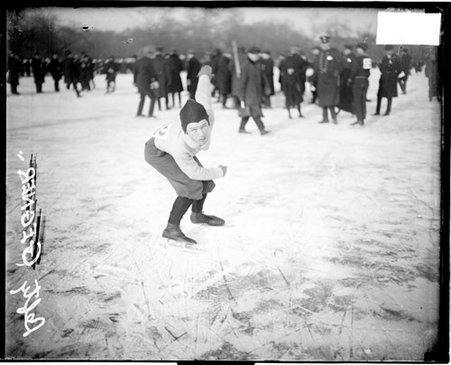 Ice skater, Lefty Gegner wearing ice skates and leaning forward in a ready position on a frozen body of water - Chicago Daily News, Inc.