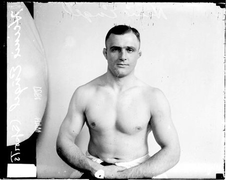 Wrestler, Heine Engel sitting in front of a light-colored backdrop in a room - Chicago Daily News, Inc.