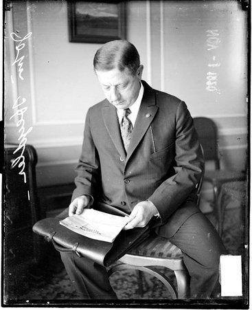 National League baseball president John Heydler looking at a piece of paper that he is holding in a room - Chicago Daily News, Inc.