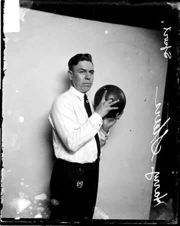 Bowler, Harry Steers holding a bowling ball, standing in front of a light-colored backdrop in a room - Chicago Daily News, Inc.