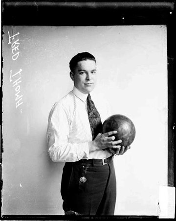 Bowler, Fred Thoma holding a bowling ball, standing in front of a light-colored backdrop in a room - Chicago Daily News, Inc.