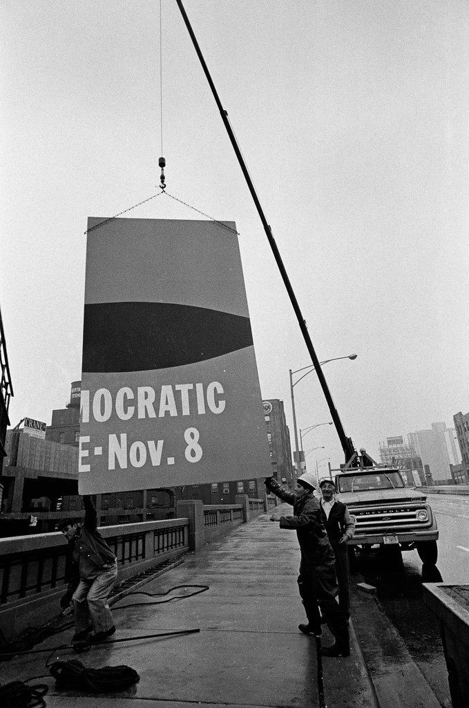 Workers taking down a large Vote Democratic sign - Chicago Sun-Times