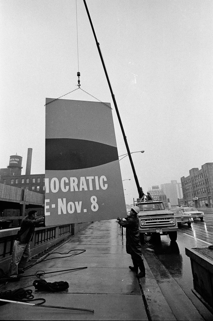 Workers taking down a large Vote Democratic sign - Chicago Sun-Times