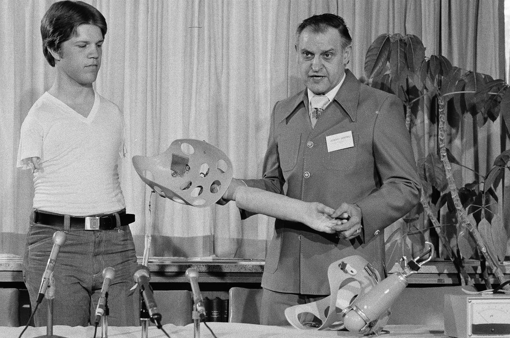 Dr. Raymond Pellicore demonstrating prosthetic arms - Chicago Sun-Times