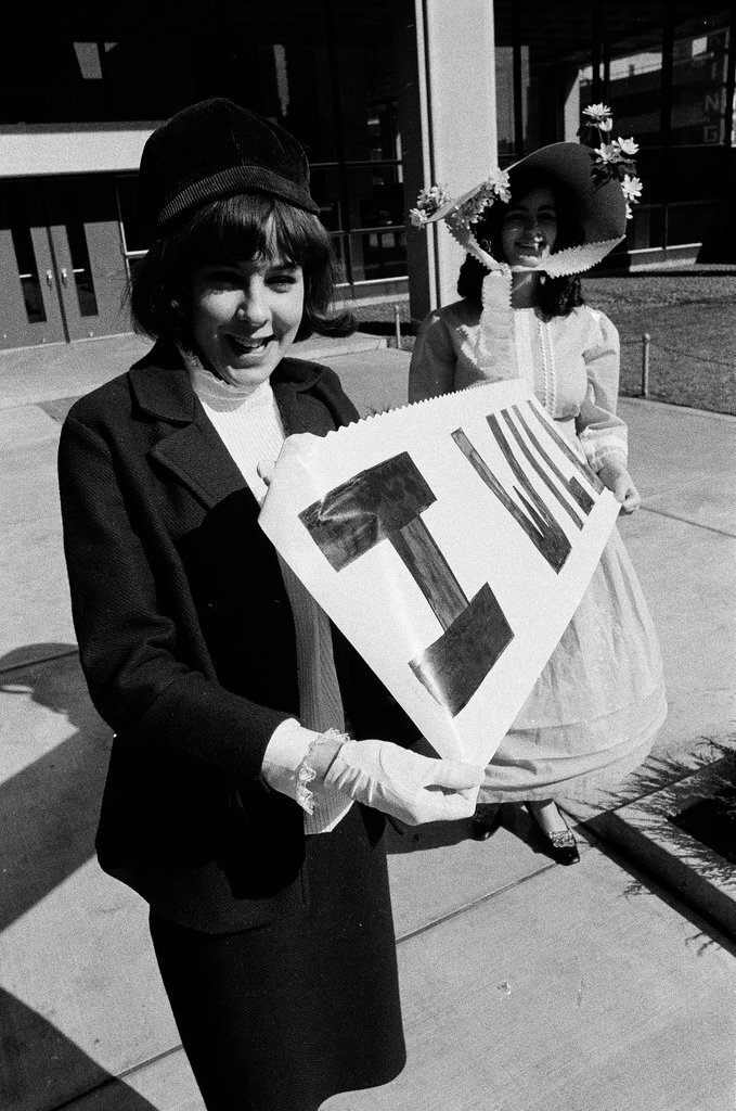 Two students dressed in historical and contemporary costumes holding a banner - Chicago Sun-Times