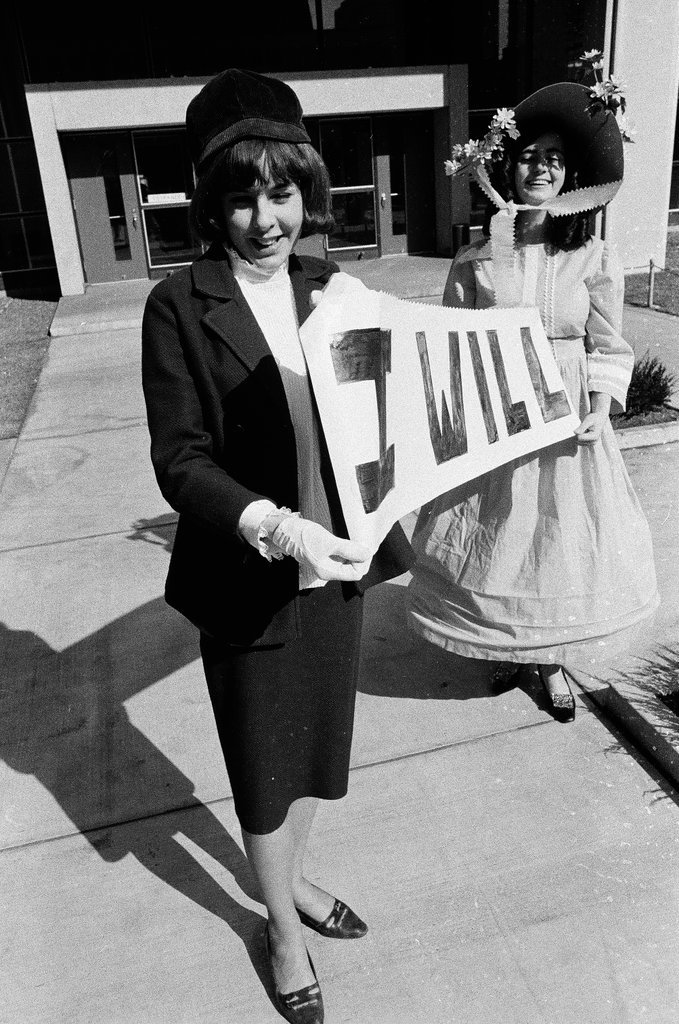 Two students dressed in historical and contemporary costumes holding a banner - Chicago Sun-Times