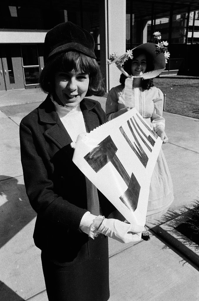 Two students dressed in historical and contemporary costumes holding a banner - Chicago Sun-Times